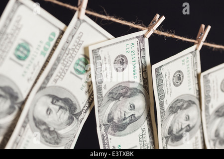 Hundred Dollar Bills Hanging From a Clothesline on a Dark Background. Stock Photo