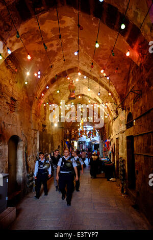 Israel, Jerusalem. 29th June, 2014. Israeli police patrol in an alley in the Muslim Quarter with festive lights during the Muslim holy month of Ramadan in the Old City of Jerusalem on 29 June 2014.  Muslims worldwide observe Ramadan as a month of fasting and it is regarded as one of the Five Pillars of Islam. Credit:  Eddie Gerald/Alamy Live News Stock Photo