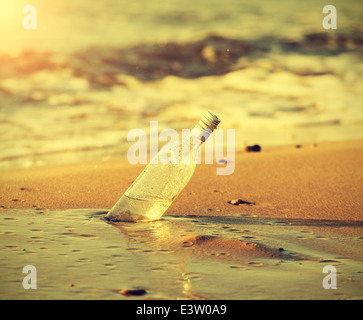 Water in bottle on sand on tropical beach Stock Photo - Alamy