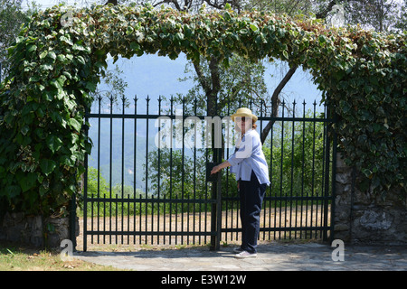 Woman closing garden home property security gate gates Stock Photo