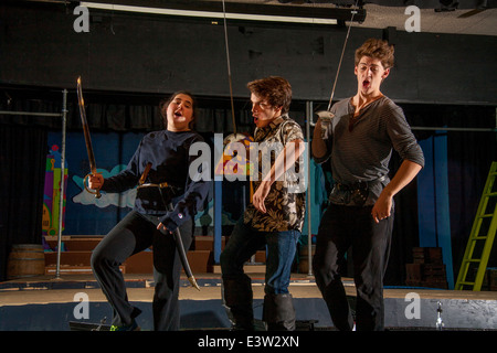 High school student cast members brandish swords and shout during rehearsal of Gilbert & Sullivan's 'Pirates of Penzance' in San Clemente, CA. Note scenery in background. Stock Photo