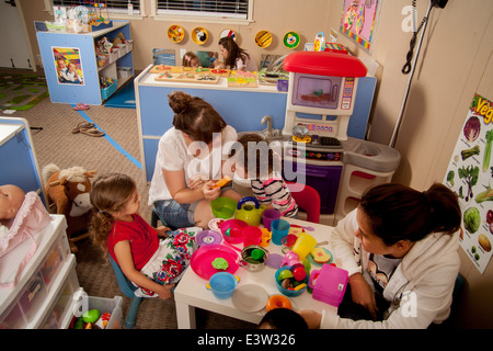 Multiracial mothers and their toddler children attend a 'Learning Link' interactive classroom. Using specially designed activities, the class teaches parents how to engage their children in meaningful play. Stock Photo