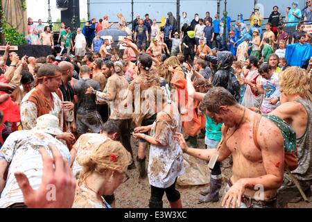 Glastonbury, Somerset, UK. 29th June 2014. Glastonbury Festival, 29th June, 2014: Tomato pulp mixed with the mud covering hundreds of people taking part in a giant tomato fight. The fight was held in the Temple venue, which is part of the 'Common' in the south east part of the festival site Credit:  Tom Corban/Alamy Live News Stock Photo