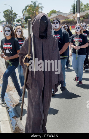 Dressed in 'Grim Reaper' costumes, high school students participate in a dramatization of an auto accident caused by drunk driving for the education of schoolmates in Anaheim, CA. Note grotesque makeup and 'Every Fifteen Minutes' t shirts supplied by the organization sponsoring the event. Stock Photo