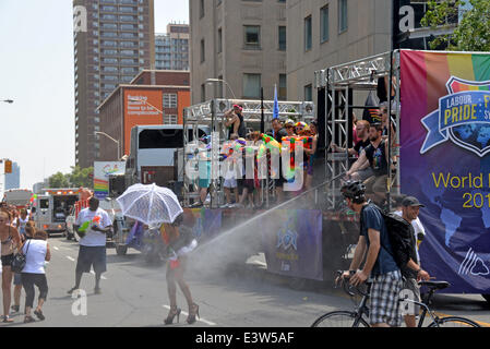 Toronto, Canada. June 29th, 2014.  WorldPride parade participant gladly accepts the spray of water from a hose in the heat. Credit:  Paul McKinnon/Alamy Live News Stock Photo