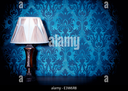 Vintage lamp on blue rococo pattern background. Victorian. Retro. Illumination. Wooden lamp on pattern background Stock Photo