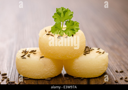 rolled harz cheese with parsley and caraway seed on wood Stock Photo