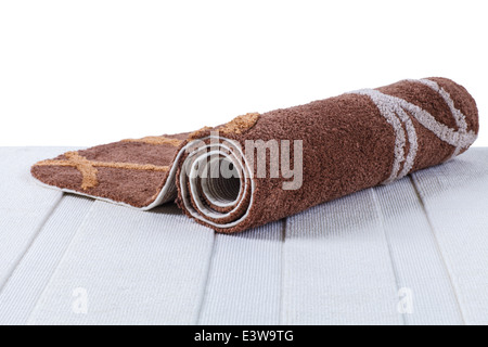 brown carpet rolled up on white carpet Stock Photo