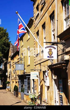 Union Jack flag on a flagpole attached the wall of the Royal British Legion building along the High Street, Chipping Campden, UK Stock Photo