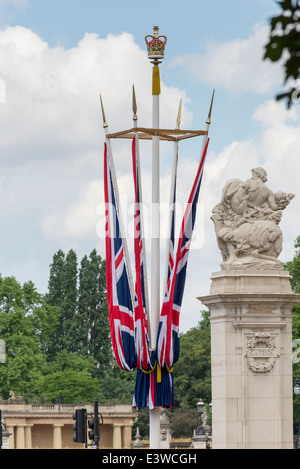 Four Union Jack flags suspended from a flag pole lining The Mall, leading up to Buckingham Palace. Stock Photo