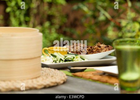 Crispy aromatic duck, shredded on a platter with cucumber and spring onion strips, and hoisin sauce Stock Photo