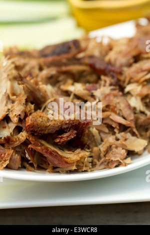 Crispy aromatic duck, shredded on a platter with cucumber and spring onion strips, and hoisin sauce Stock Photo