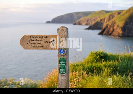 Sign for coastal path early evening overlooking the cliffs of Pembrokeshire coast, west Wales. Near Ceibwr Bay Stock Photo