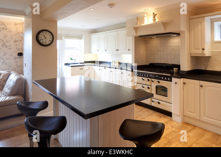 Bar stools at breakfast bar in modern country style kitchen, Cheshire, UK Stock Photo