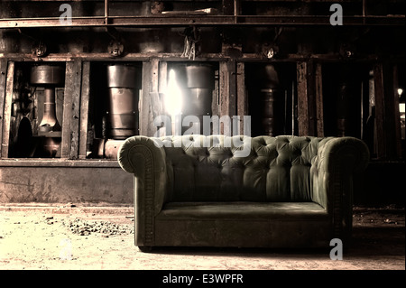 Couch in an abandoned industrial background Stock Photo