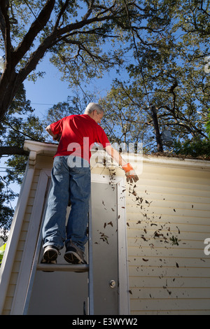 Mature Man Cleaning House Gutters, USA Stock Photo