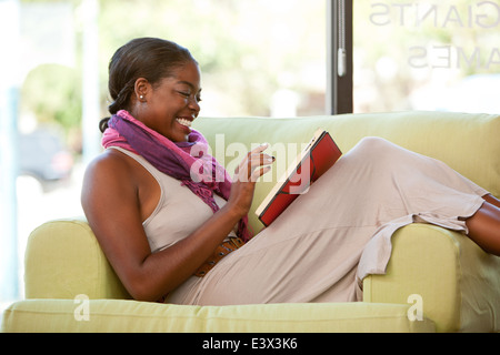 Happy ethnic woman using tablet device to browse web. Stock Photo