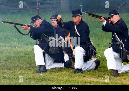 Confederate marines firing rifles on Union troops as part of an American Civil War battle re-enactment Stock Photo