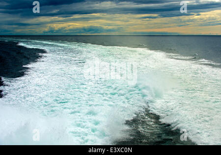 Spray in a ship wake at sea, at sunset, North Sea Stock Photo