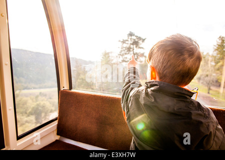 Caucasian boy looking out tram window Stock Photo