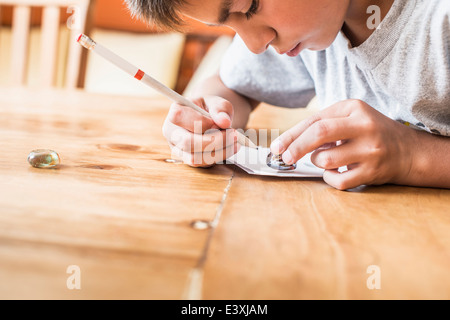Mixed race boy coloring at desk Stock Photo