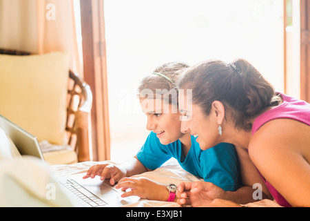 Mother and daughter using laptop at desk Stock Photo