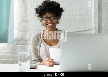 Mixed race architect working at desk Stock Photo