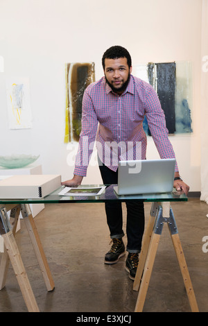 Mixed race man working in art gallery Stock Photo