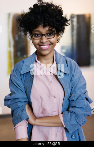 Mixed race woman smiling in art gallery Stock Photo