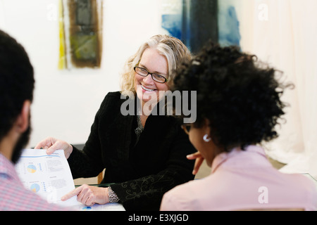Businesswoman talking to young couple Stock Photo