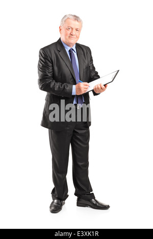 Full length portrait of a mature businessman taking notes on piece of paper Stock Photo