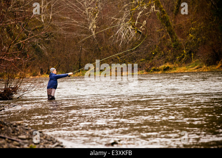 Man fly fishing in rural river Stock Photo