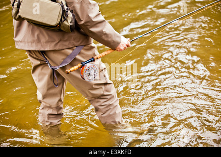 Man fishing in rural river Stock Photo