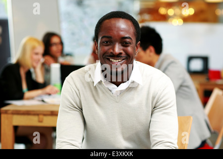 Portrait of smiling businessman sitting in front of colleagues Stock Photo