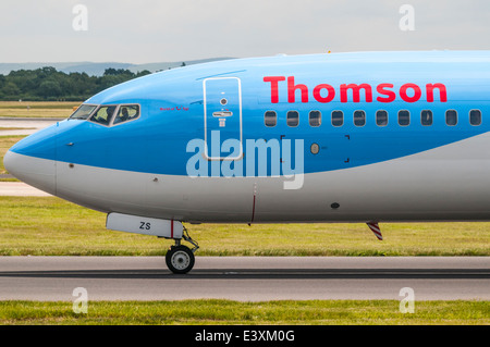 Side view of the front of a Thomson Boeing 737 plane as it passes on a taxiway at Manchester Airport Stock Photo