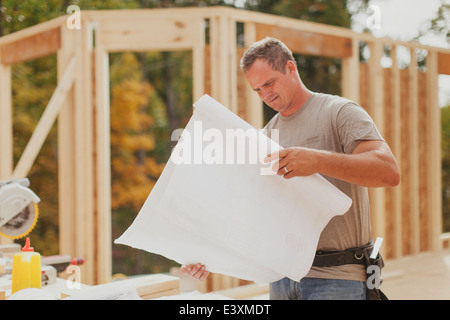 Caucasian construction worker reading blueprints on site Stock Photo
