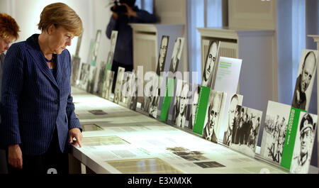 Berlin, Germany. 1st July, 2014. German Chancellor Angela Merkel (CDU) reads in front of portraits of German resistance fighters as she visits the opening of the permanent exhibition at the 'German Resistance Memorial Center' in Berlin, Germany, 01 July 2014. Photo: MICHAEL SOHN/DPA/Alamy Live News Stock Photo