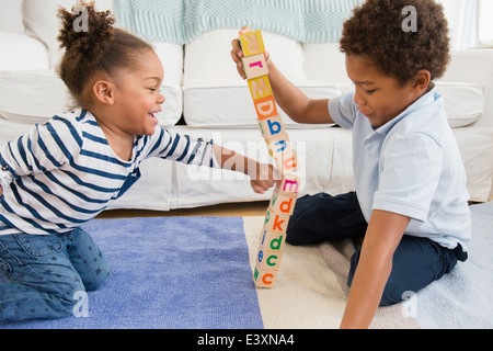 Black children playing with blocks in living room Stock Photo