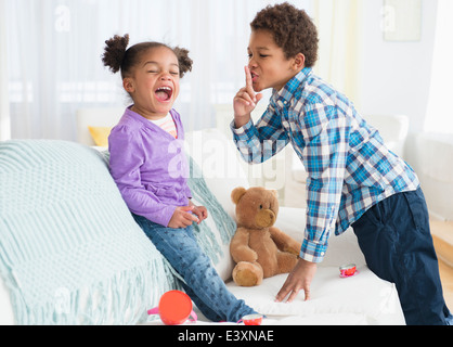 Black children playing on sofa Stock Photo