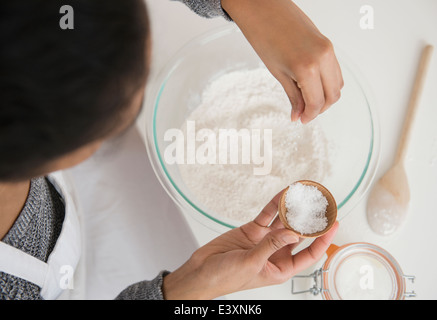 Mixed race woman baking in kitchen Stock Photo