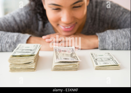 Mixed race woman counting stacks of money Stock Photo