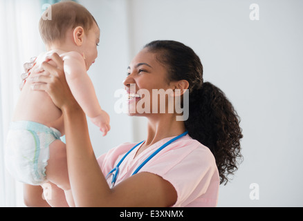 Nurse holding baby in hospital Stock Photo