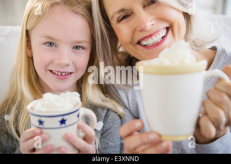 Senior Caucasian woman and granddaughter drinking hot cocoa Stock Photo