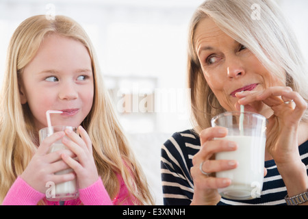 Senior Caucasian woman and granddaughter drinking milk Stock Photo