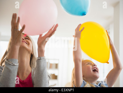 Senior Caucasian woman and granddaughter playing with balloons Stock Photo