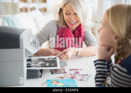 Senior Caucasian woman and granddaughter printing photos Stock Photo