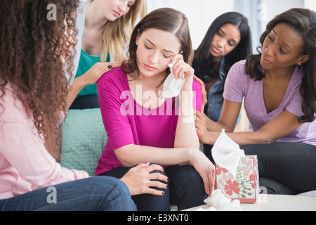 Crying woman surrounded by friends Stock Photo