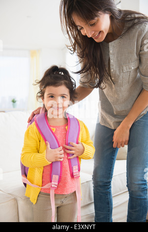 Hispanic mother getting daughter ready for school Stock Photo