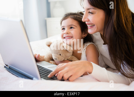 Hispanic mother and daughter using laptop together Stock Photo