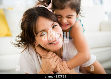 Hispanic mother and daughter playing in living room Stock Photo